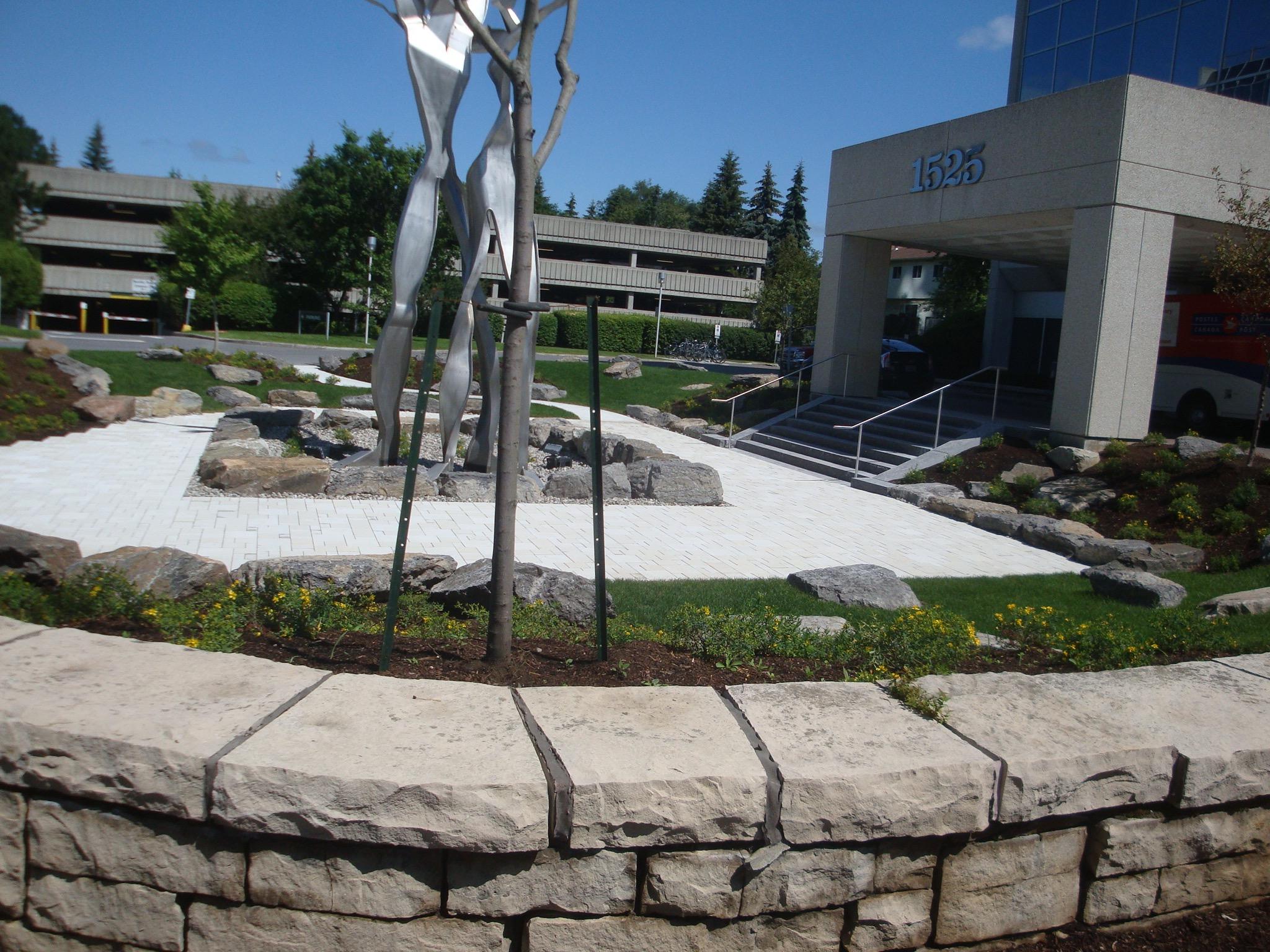 Institutional landscape — pavers, planting and building integration, Ottawa region. GJA Inc.